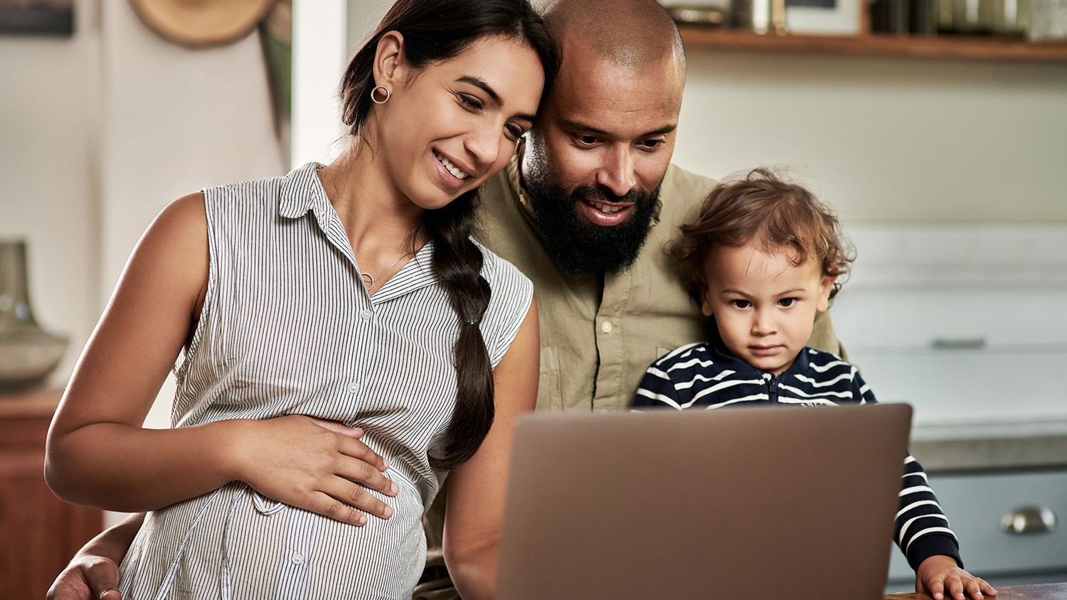 Family using laptop happy young family using a laptop together at home