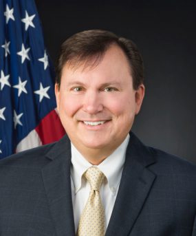 A head and shoulders photo of ATSDR Associate Director Christopher M. Reh, Ph.D. in front of a U.S. flag