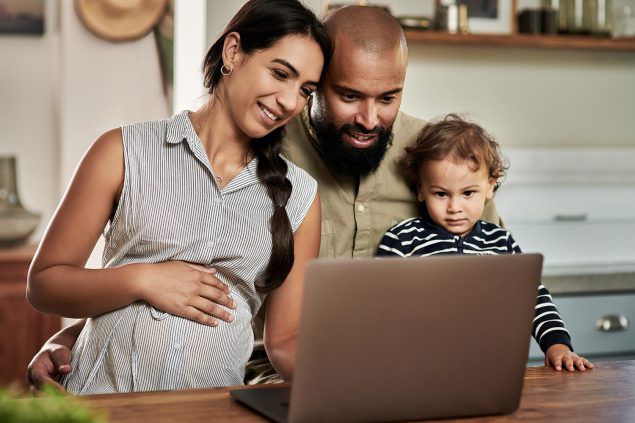 Shot of a happy young family using a laptop together at home. Shot of a happy young family using a laptop together at home.