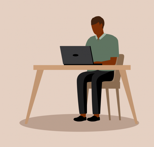 A faceless man sitting at a desk typing on a laptop.