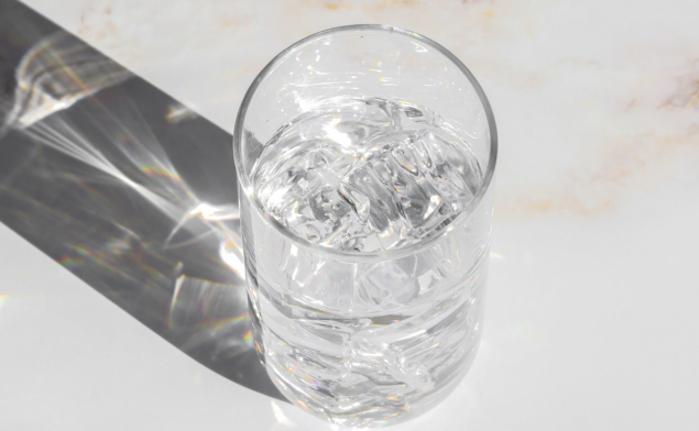 Glass of ice water on a white counter.