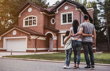 Una familia afuera de su nuevo hogar.
