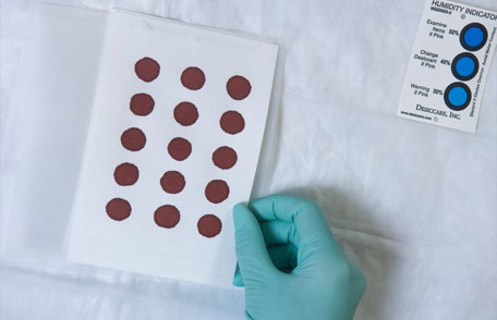 Calidad de las pruebas del recién nacido Un técnico en realizar una prueba de laboratorio.