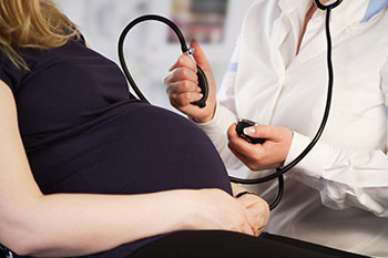 Pregnant woman having blood pressure taken