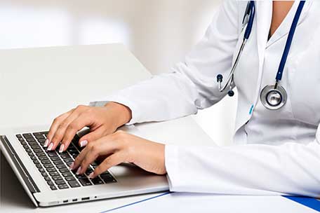 physician typing on keyboard.