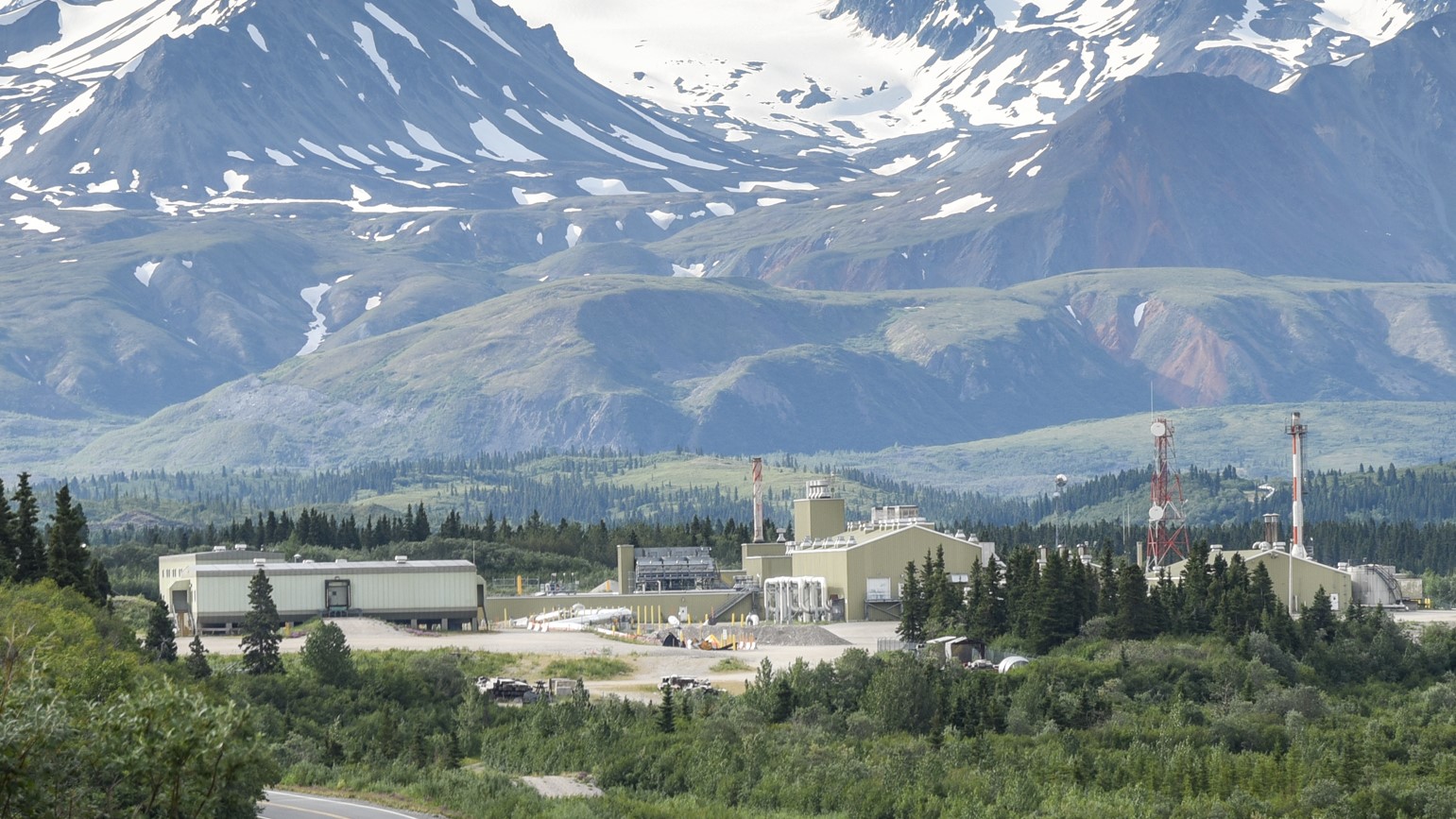 region 10 Trans Alaska pipeline pump station in a summer valley with snow-capped mountains.