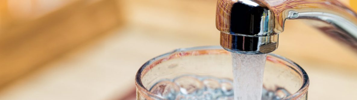 Filling up a glass with drinking water from kitchen tap Filling up a glass with drinking water from kitchen tap