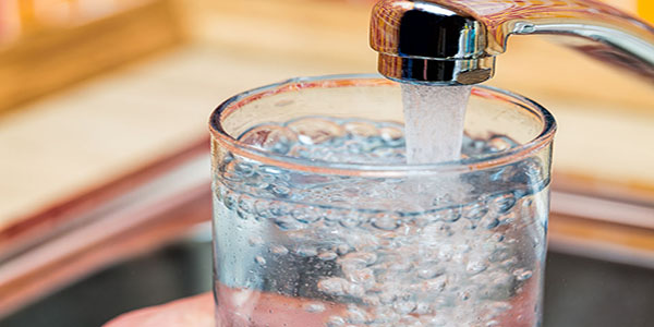 Filling up a glass with drinking water from kitchen tap Filling up a glass with drinking water from kitchen tap