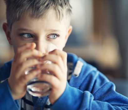 Portrait of a little boy drinking a glass of water
