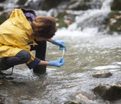 Ecologista investigador tomando una muestra de agua en el bosque