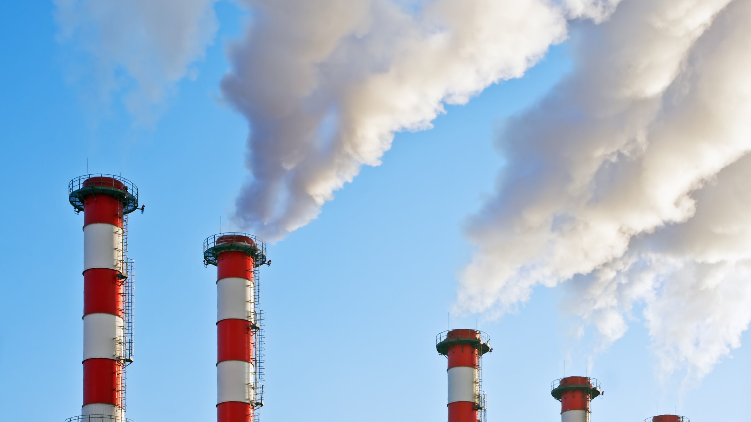 Five smokestacks releasing contaminants into the air.