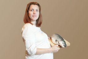 Pregnant women holding salmon on cutting board