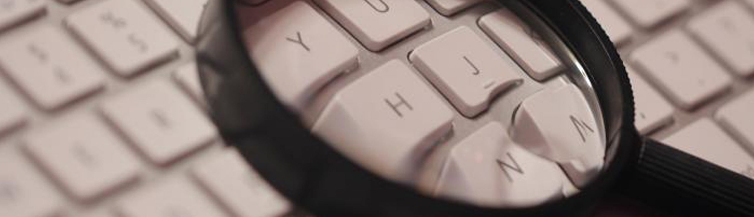 A magnifying glass laying on top of a keyboard