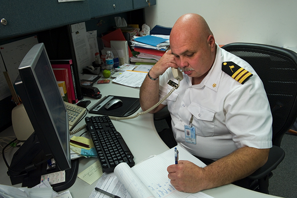 Man in uniform answering phone and taking notes