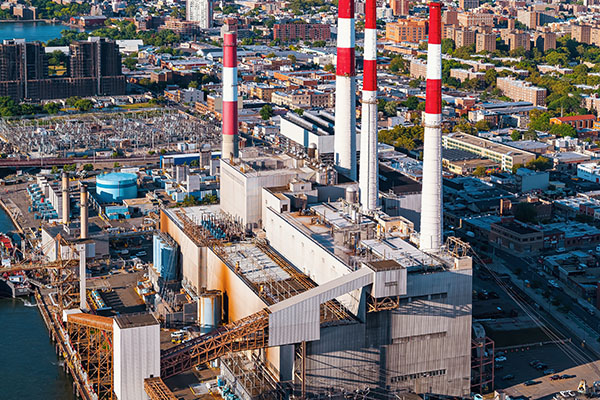 Aerial view of a power plant with multiple red and white smokestacks