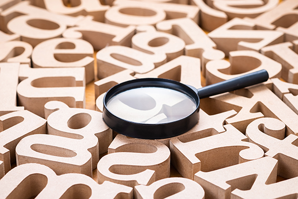 Magnifying glass on top of wooden alphabet