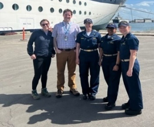 Staff standing in front of cruise ship.