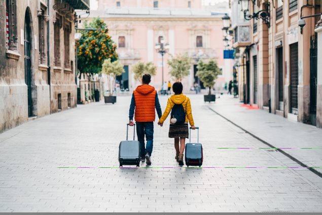 Couple walking with suitcases.