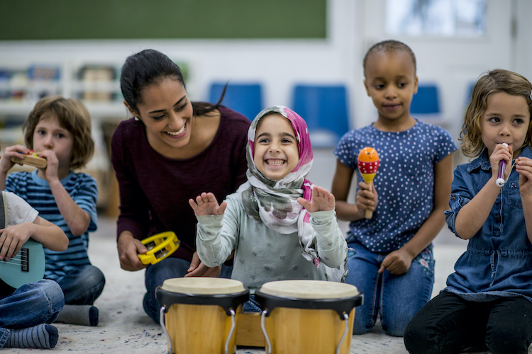 Preschool teacher with her students during music time.