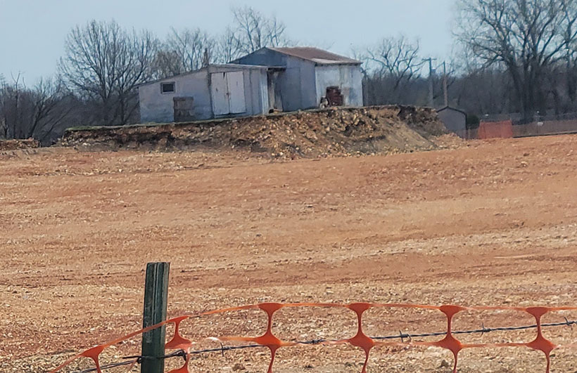 Soil clean up activities. Bare soil can be see in the foreground surrounding a home.