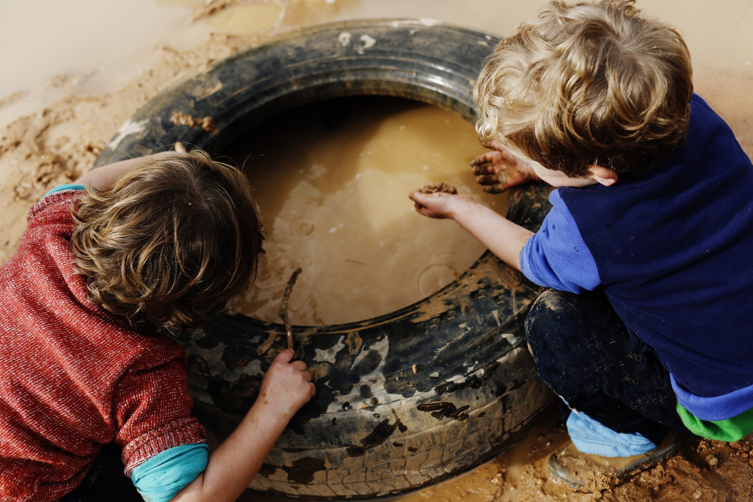 children playing with mud and dirty water children playing with mud and dirty water in the woods having fun in mud puddles
